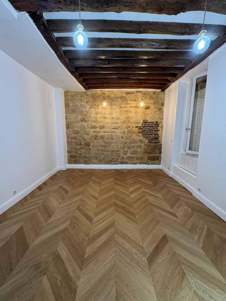 Artisan en train de poser un parquet en point de Paris